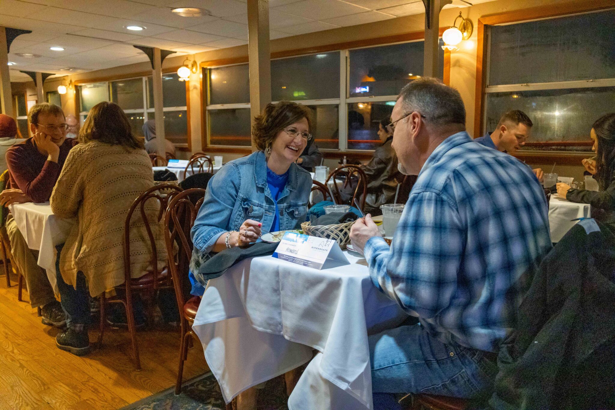 Two happy guests smiling while they eat on a Skyline Dinner Cruise.