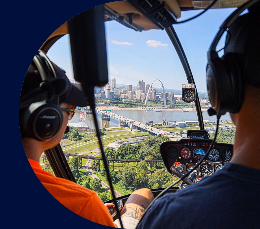 Helicopter page header image, includes a photo of a helicopter and passenger flying over Saint Louis on a summer day.