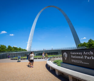 Visitors walking into the visitor center at Gateway Arch National Park on a gorgeous sunny day