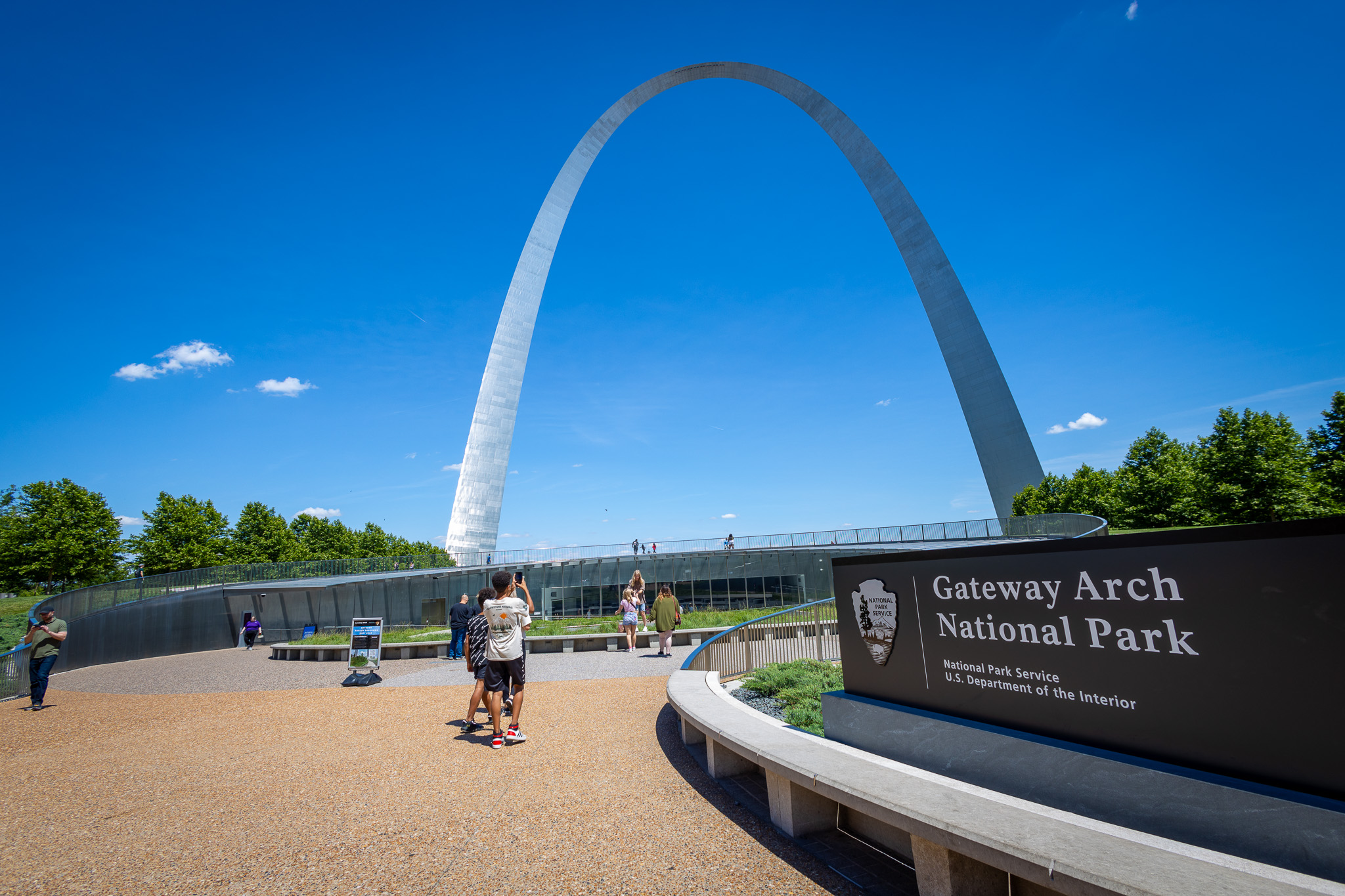 Visitors walking into the visitor center at Gateway Arch National Park on a gorgeous sunny day