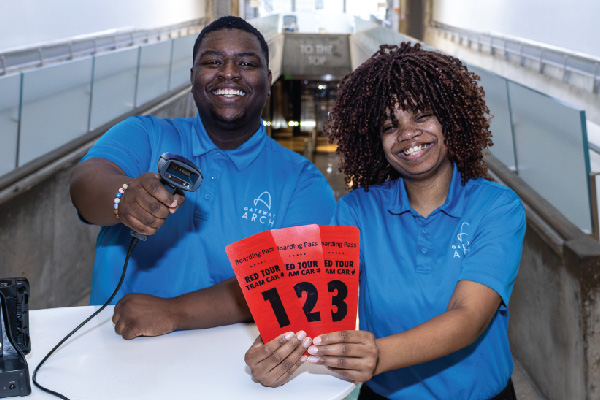 Two Tour Guides at the Gateway Arch smiling and posing for a photo before a Tram Ride to the Top tour.