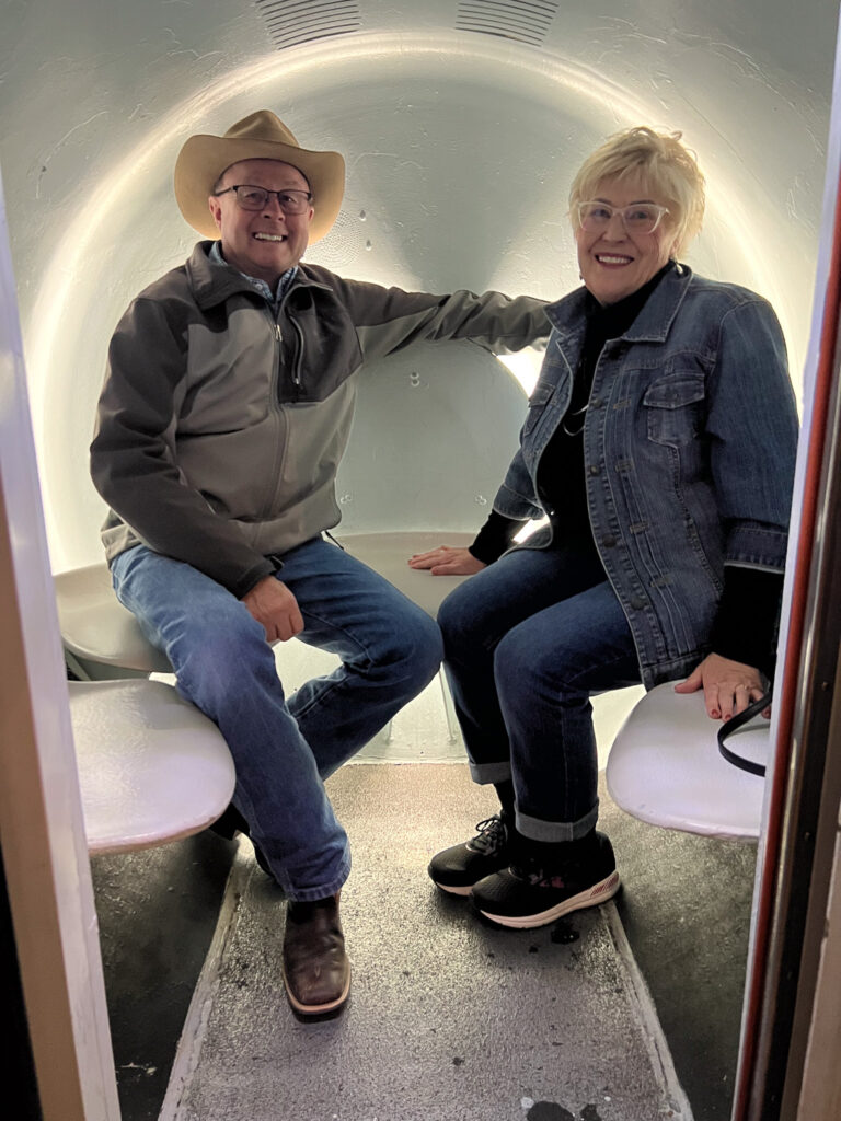 A couple sit in a spacious pod as part of the Tram Ride to the Top of the Gateway Arch.