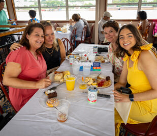 A group of four women eating on a Brunch Cruise aboard the Riverboats at the Gateway Arch.